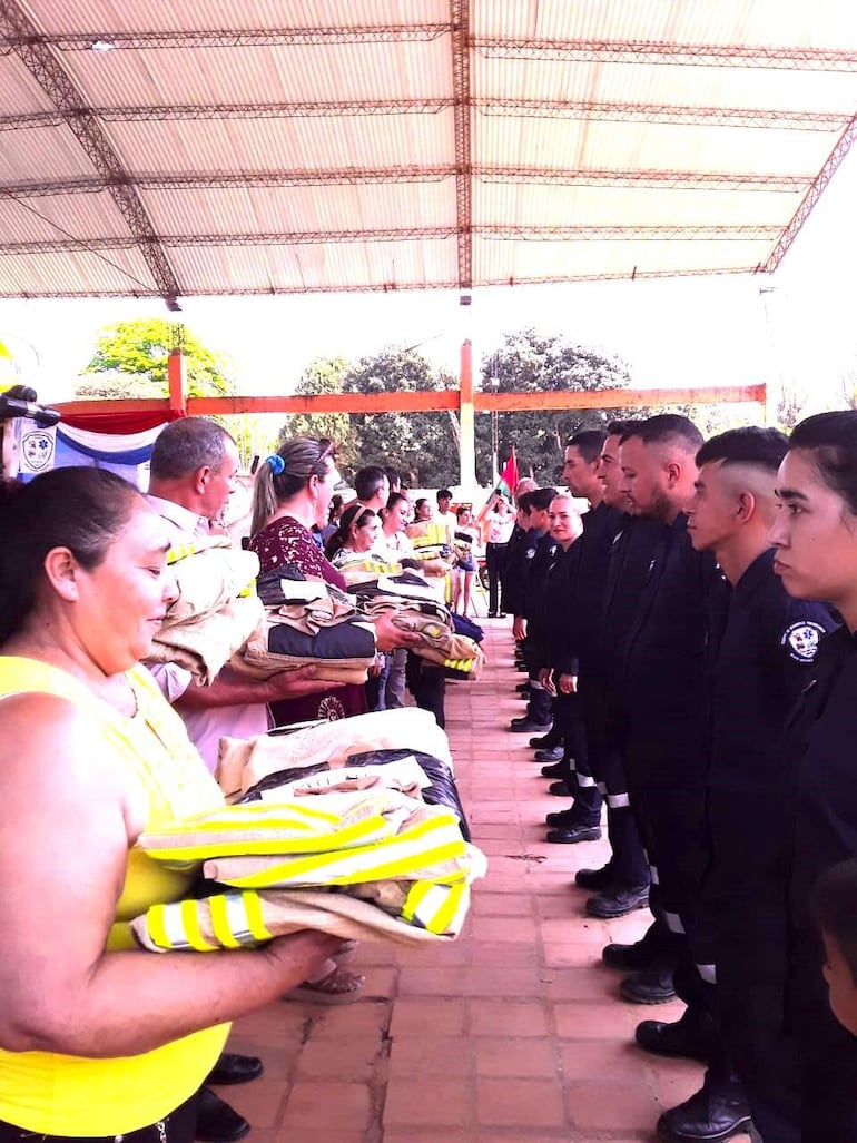 Los bomberos reciben las donaciones de sus respectivas indumentarias para el servicio.