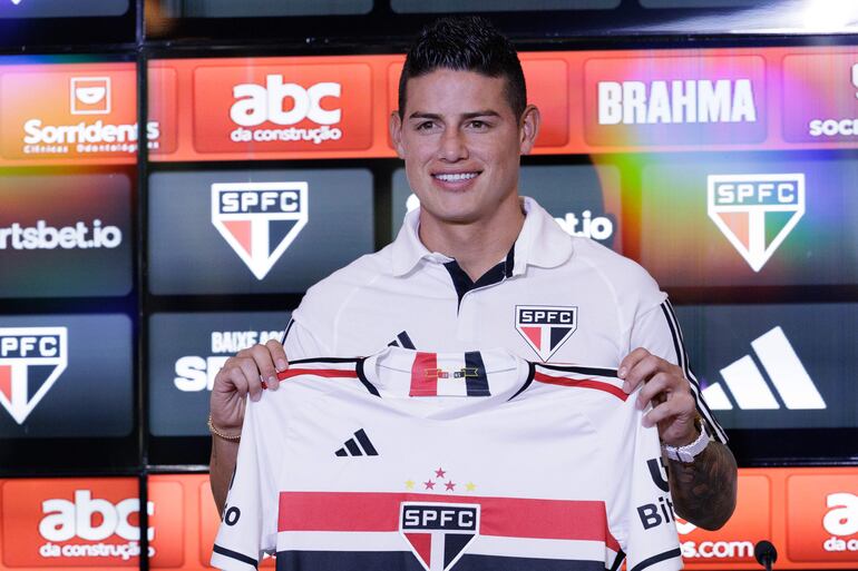 BRA100. SAO PAULO (BRASIL), 01/08/2023.- El futbolista colombiano James Rodríguez sostiene la camiseta del Sao Paulo, durante su presentación como nuevo jugador del club, en Sao Paulo (Brasil). El Sao Paulo de Brasil anunció este martes en su centro de formación la contratación del centrocampista colombiano James Rodríguez, que estaba sin vínculos desde su salida del Olympiacos griego y con el que firmó un contrato que lo vincula hasta junio de 2025. EFE/ Isaac Fontana