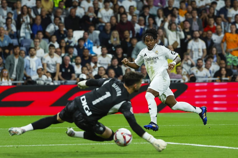 El delantero brasileño del Real Madrid, Endrick (d), remata ante el guardameta del Alavés, Antonio Sivera, durante el encuentro correspondiente a la séptima jornada de Laliga EA Sports que Real Madrid y Alavés disputan hoy martes en el estadio Santiago Bernabéu, en Madrid.