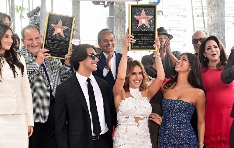 Los cubanos Lili Estefan y Raúl De Molina rodeados de sus familiares tras recibir sus estrellas en el Paseo de la Fama de Hollywood, California. (Frederic J. BROWN / AFP)