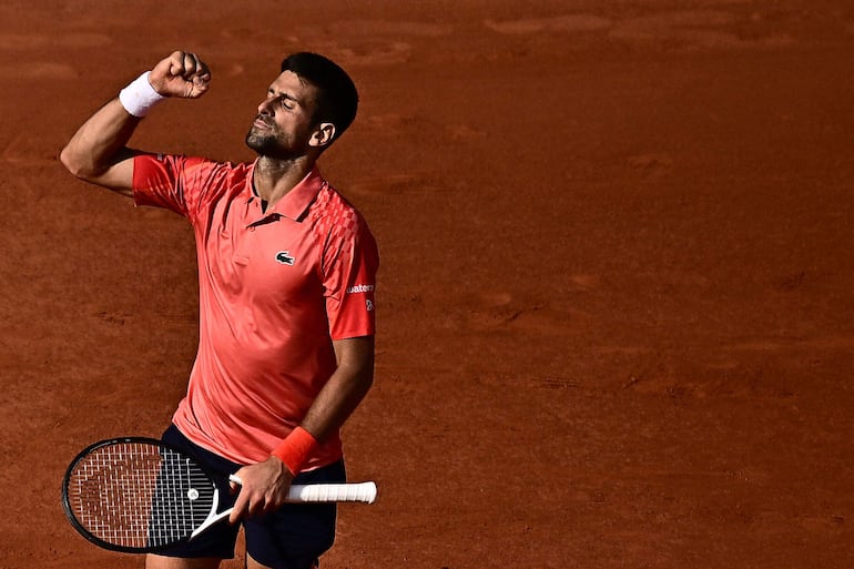 Serbia's Novak Djokovic celebrates his victory over Spain's Carlos Alcaraz Garfia during their men's singles semi-final match on day thirteen of the Roland-Garros Open tennis tournament at the Court Philippe-Chatrier in Paris on June 9, 2023. (Photo by JULIEN DE ROSA / AFP)