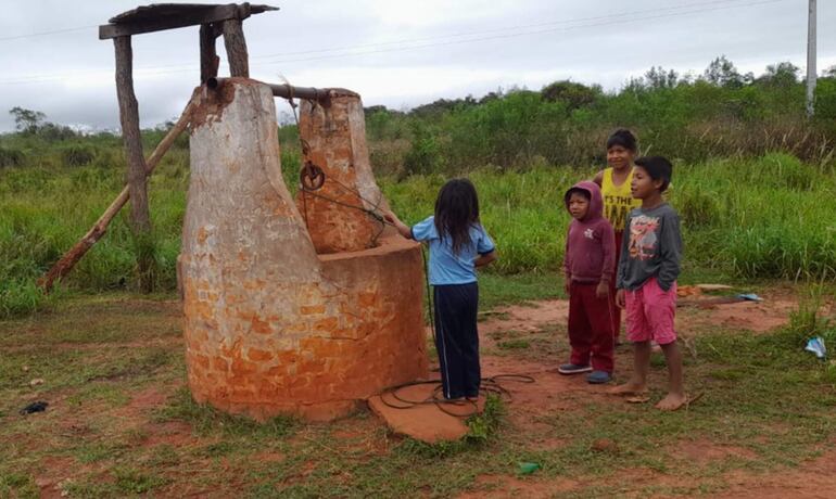 
Unos niños de la comunidad observan  el lugar donde está instalado el aljibe de agua 