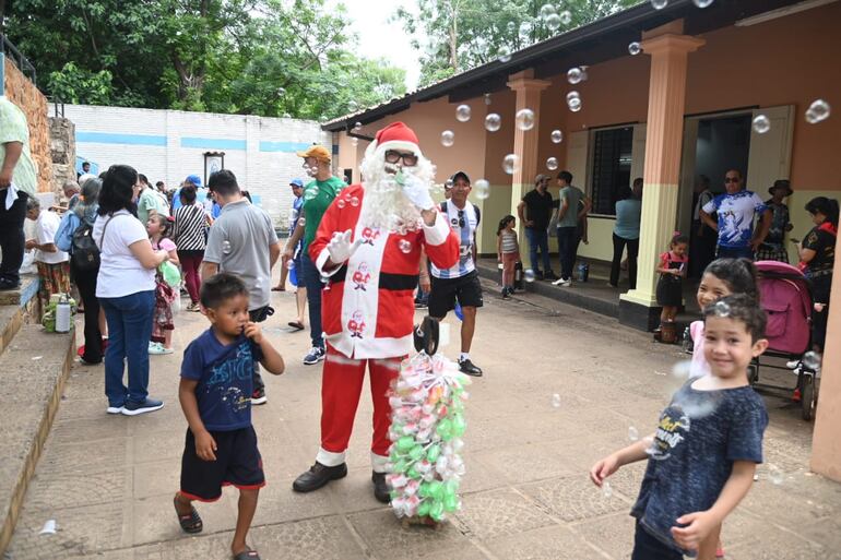 Reinaldo Ojeda, disfrazado de Papá Noel divierte a los niños lanzando burbujas en el Tupãsy Ykuá.