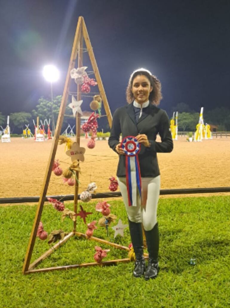 María Belén Giménez (HKE) exhibe la cucarda que la proclamó ganadora de la categoría 1.30 metro, una de las principales en el arranque del Nacional de Saltos, en el Club Hípico Paraguayo.