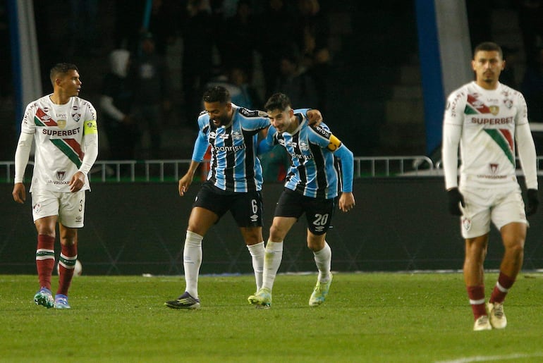 El brasileño Reinaldo (i) y el paraguayo Mathías Villasanti, jugadores de Gremio, celebran un gol en el partido ante Fluminense por los octavos de final de la Copa Libertadores 2024 en el estadio Couto Pereira, en Curutiba, Brasil.