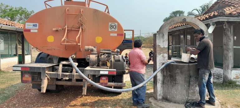 Camión del MOPC abasteciendo de  agua  a  una vivienda chaqueña. A esto se suma la reparación de caminos.