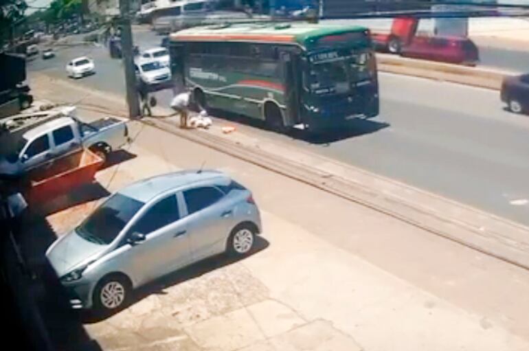 Momento en que uno de los pasajeros del bus bajó para intentar auxiliar a la arquitecta Cinthia Riquelme, que estaba tendida en el pavimento. 