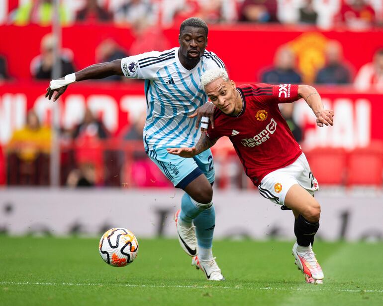 Serge Aurier (L) de Nottingham Forest en acción con Antony (R) del Manchester United durante el partido de fútbol de la Premier League inglesa entre Manchester United y Nottingham Forrest, en Manchester, Gran Bretaña, el 26 de agosto de 2023.