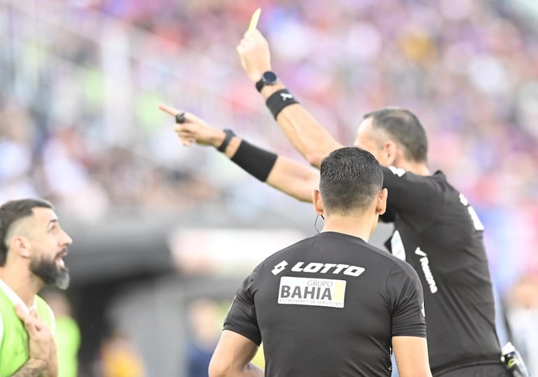 Lucas Pratto (i), jugador de Olimpia, es amonestado por el árbitro Juan Gabriel Benítez durante el partido frente a Cerro Porteño por la fecha 17 del torneo Clausura 2024 del fútbol paraguayo en el estadio Defensores del Chaco, en Asunción, Paraguay.