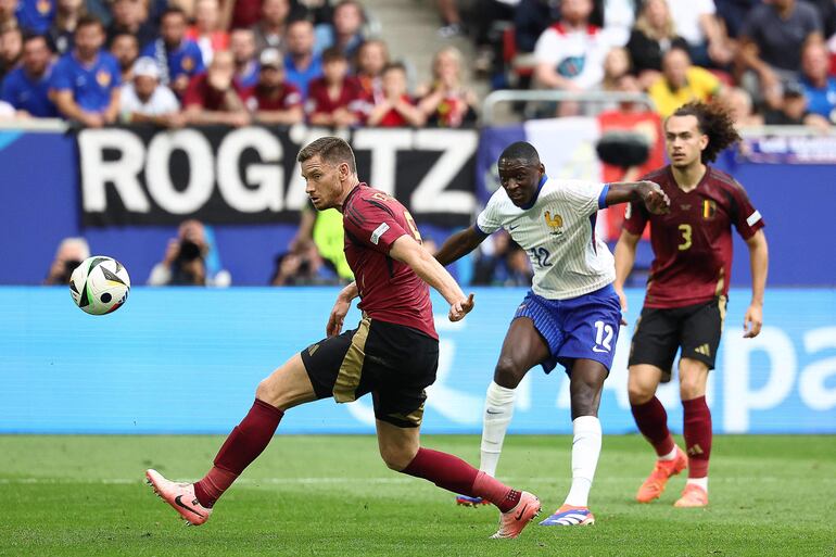 TOPSHOT - France's forward #12 Randal Kolo Muani shoots on target and Belgium's defender #05 Jan Vertonghen (L) scores an own goal during the UEFA Euro 2024 round of 16 football match between France and Belgium at the Duesseldorf Arena in Duesseldorf on July 1, 2024. (Photo by FRANCK FIFE / AFP)