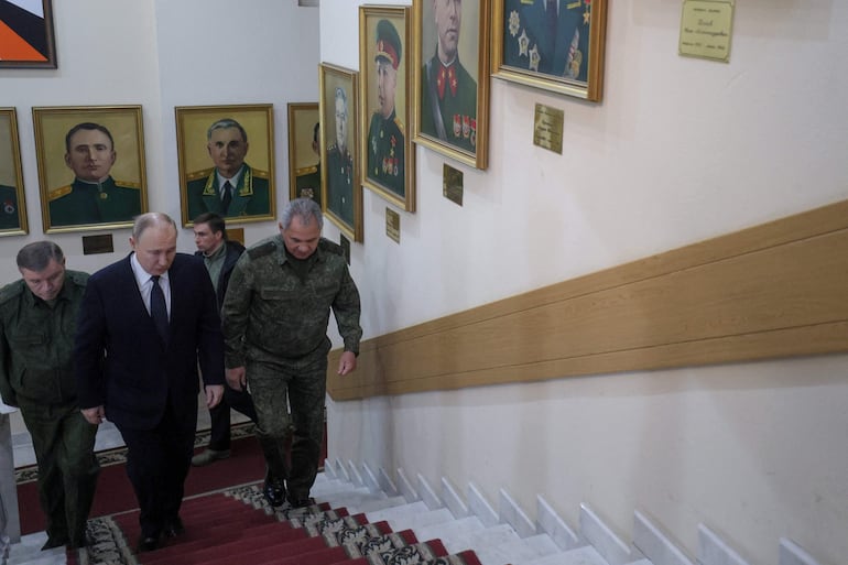 Imagen cedida por la agencia rusa Sputnik en la que se observa al presiden ruso Vladimir Putin junto a miembros de las Fuerzas Armadas.  (AFP)