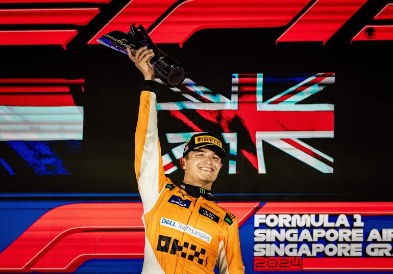 Lando Norris, con la copa en alto, festeja el triunfo conseguido ayer. El inglés le recortó 7 puntos a Max Verstappen.