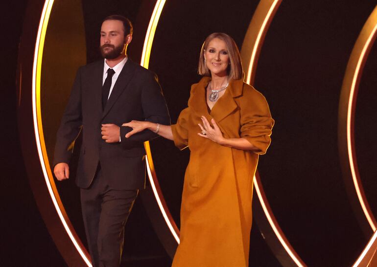 Celine Dion ingresando al escenario del Crypto.com Arena de brazos de su hijo mayor, René-Charles Angelil. (Amy Sussman/Getty Images/AFP)
