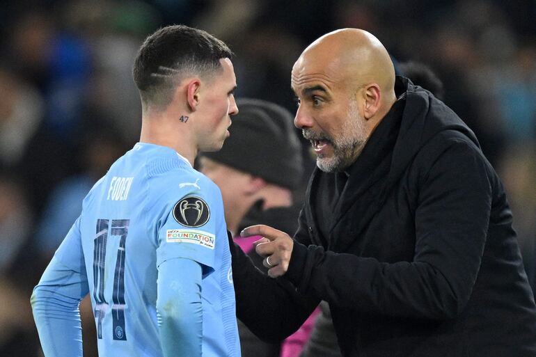 Pep Guardiola hablando con Phil Foden durante una pausa de un partido del Manchester City.