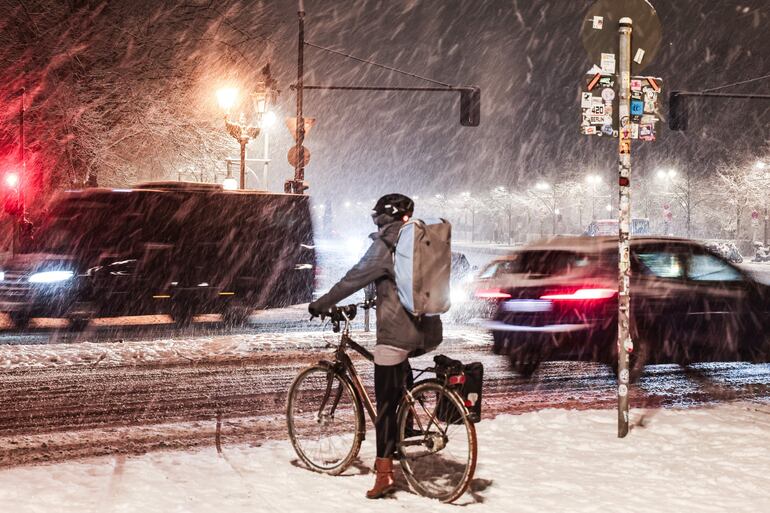 Un ciclista espera a los automovilistas durante una fuerte nevada en Berlín, Alemania.