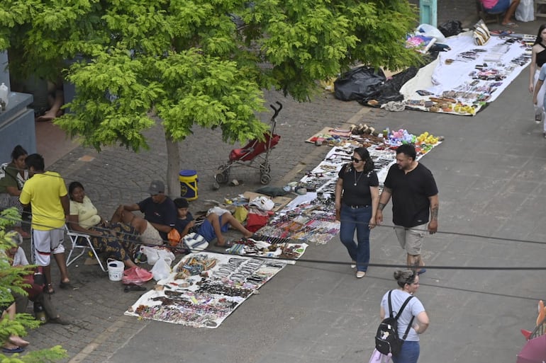 Una pareja de peregrinos observa los productos que ofrecen los indígenas frente al Santuario..