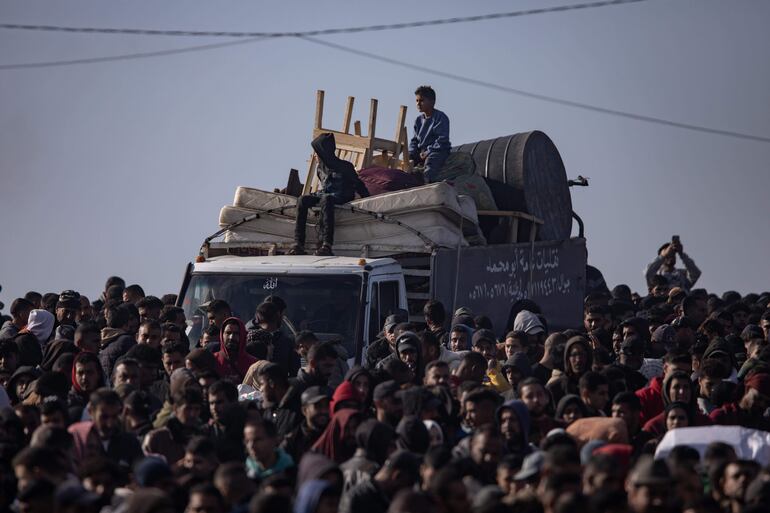 Palestinos desplazados esperan para retornar al norte de la Franja de Gaza, este domingo.