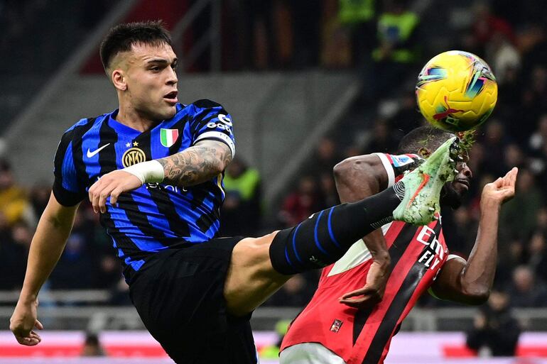 TOPSHOT - Inter Milan's Argentine forward #10 Lautaro Martinez (L) fights for the ball with AC Milan's English defender #23 Fikayo Tomori during the Italian Serie A football match between AC Milan and Inter at San Siro stadium in Milan, on February 2, 2025. (Photo by PIERO CRUCIATTI / AFP)