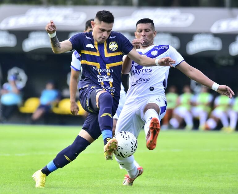 Alex Álvarez, del Sportivo Trinidense, pelea el balón con Fabián Franco, del Sportivo Ameliano.