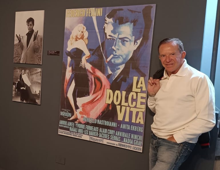 Nestor Saied, curador de la muestra "Ciao Marcello" junto a algunas imágenes de la película "La Dolce Vita" que se exponen en la Manzana de la Rivera.