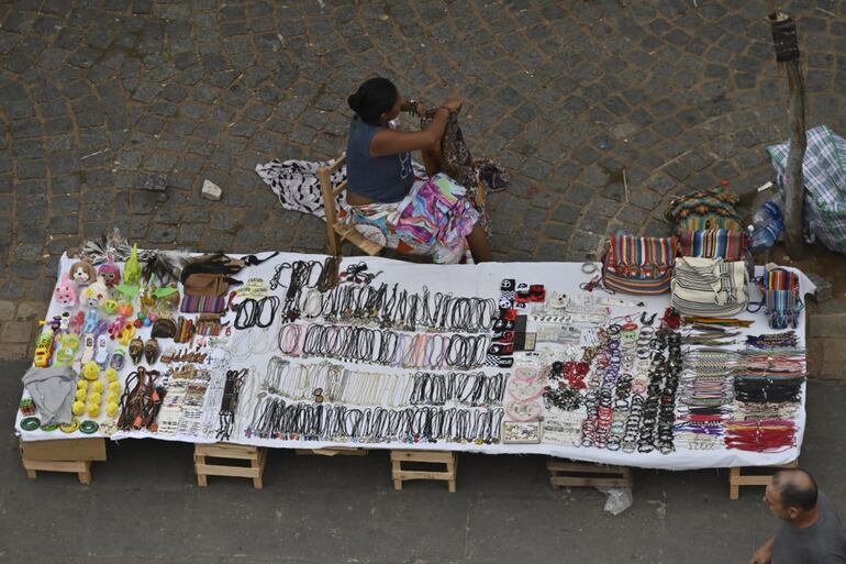 Una mujer indígena expone sus productos de artesanía frente a la explanada de la Basílica.