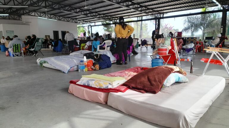 Los familiares de pacientes instalados en el albergue del Hospital Central de IPS llevan sus colchones para pasar la noche en el lugar.