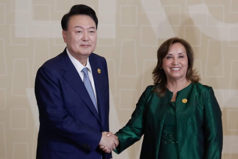 La presidenta de Perú, Dina Boluarte (d), saluda al presidente de Corea del Sur, Yoon Suk-yeol (i).