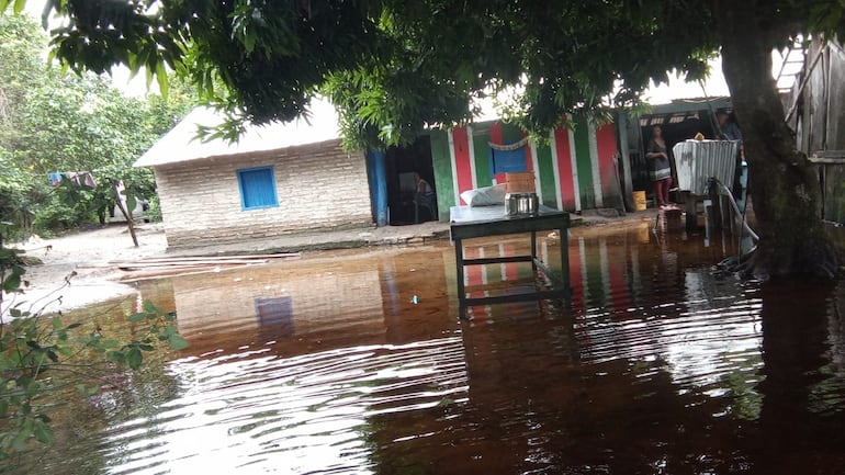 Pobladores de Tacuara - Ñeembucú - esperan asistencia en medio del agua.