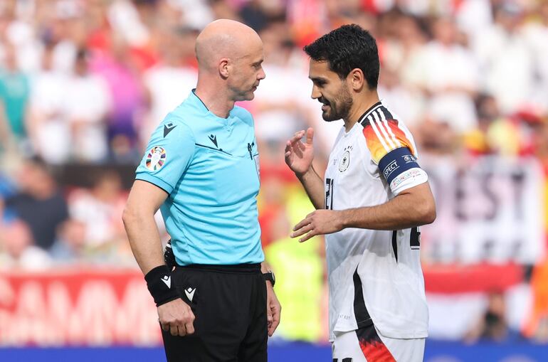 Stuttgart (Germany), 05/07/2024.- Ilkay Guendogan of Germany (R) talks to referee Anthony Taylor during the UEFA EURO 2024 quarter-finals soccer match between Spain and Germany, in Stuttgart, Germany, 05 July 2024. (Alemania, España) EFE/EPA/FRIEDEMANN VOGEL
