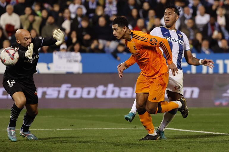 LEGANÉS (MADRID), 24/11/2024.- El centrocampista inglés del Real Madrid, Jude Bellingham (c), supera al guardameta serbio del Leganés, Marko Dmitrovic, para conseguir el tercer gol del equipo madridista durante el encuentro correspondiente a la jornada 14 de Laliga EA Sports que disputan hoy domingo Leganés y Real Madrid en el estadio de Butarque, en Leganés. EFE / Sergio Pérez.
