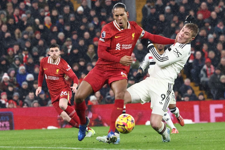 Liverpool's Dutch defender #04 Virgil van Dijk (C) vies with Manchester United's Danish striker #09 Rasmus Hojlund (R) during the English Premier League football match between Liverpool and Manchester United at Anfield in Liverpool, north west England on January 5, 2025. (Photo by Darren Staples / AFP) / RESTRICTED TO EDITORIAL USE. No use with unauthorized audio, video, data, fixture lists, club/league logos or 'live' services. Online in-match use limited to 120 images. An additional 40 images may be used in extra time. No video emulation. Social media in-match use limited to 120 images. An additional 40 images may be used in extra time. No use in betting publications, games or single club/league/player publications. / 