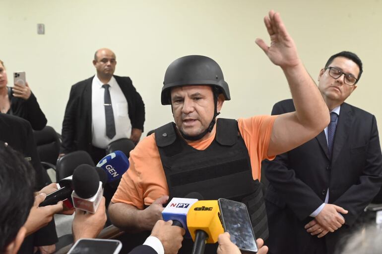 Con chaleco antibalas y casco, el pastor José Insfrán en su audiencia.