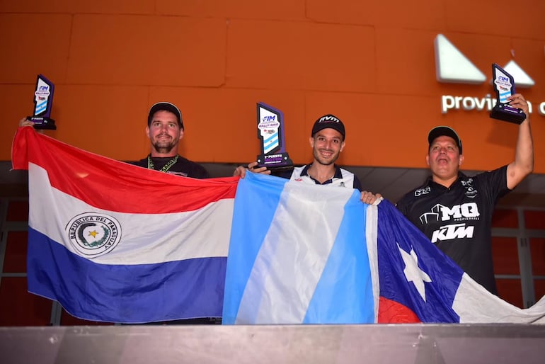 Gido Krahn (izq.) levanta en alto el trofeo y la bandera paraguaya, después de una gran carerra.