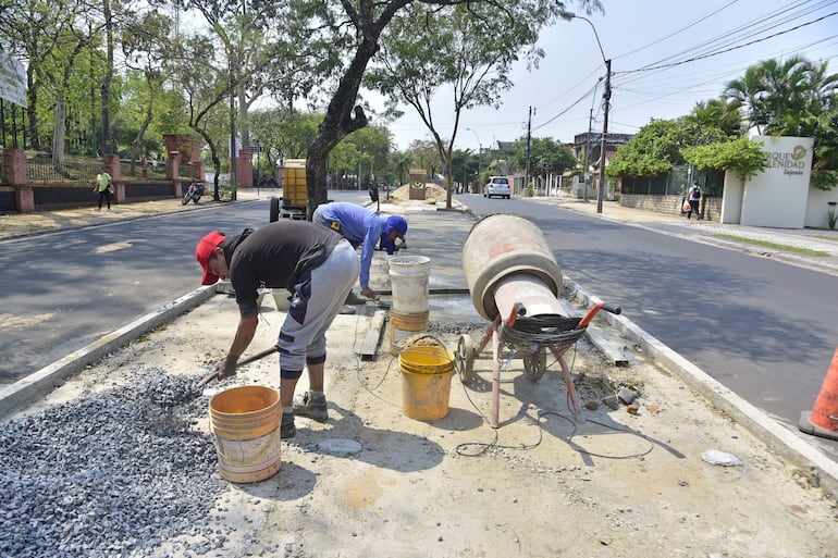 Dos hombres trabajando en un punto de la avenida Carlos Antonio López, en Asunción. Los trabajos, que están atrasados, muestran lentos avances en el paseo central.