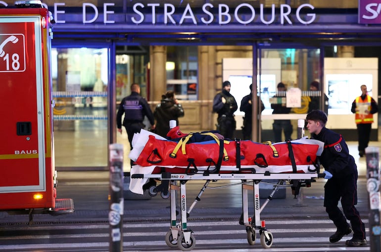 Bomberos trasladan a una persona herida tras el choque de dos trenes en Estrasburgo.