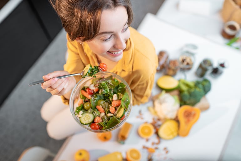 Mujer comiendo una ensalada.