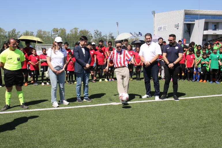 Embajador de Corea en Paraguay, Chan-sik Yoon, patea un balón en la "Copa Visión 2024", acompañado de diversas autoridades nacionales.