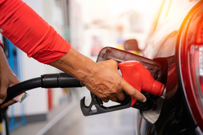 Una persona carga combustible en una estación de servicio.