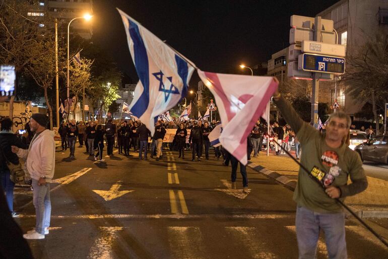 Israeli anti-government and anti-war protesters take part in a demonstration in Tel Aviv, on January 13, 2024, after almost 100 days of war between Israel and the militant Hamas group in Gaza. (Photo by MARCO LONGARI / AFP)