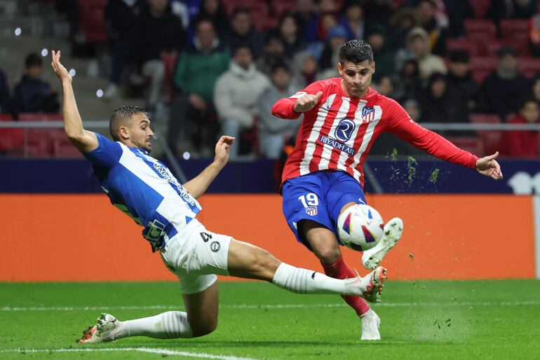 MADRID, 29/10/2023.- El delantero del Atlético de Madrid, Álvaro Morata (d), golpea el balón ante el defensa serbio del Alavés, Aleksander Sedlar, para conseguir el segundo gol del equipo rojiblanco durante el encuentro correspondiente a la jornada once de primera división que disputan hoy domingo en el estadio Metropolitano, en Madrid. EFE / Kiko Huesca.
