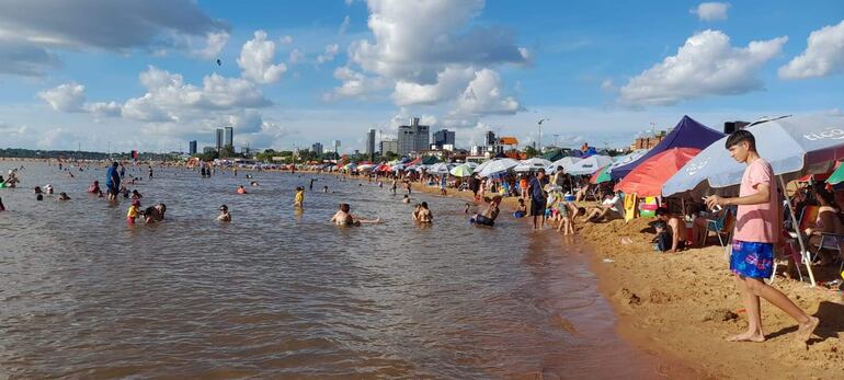 Toldos, quitasoles o sombrillas cubren la extensa playa a orillas del río Paraná en Encarnación.