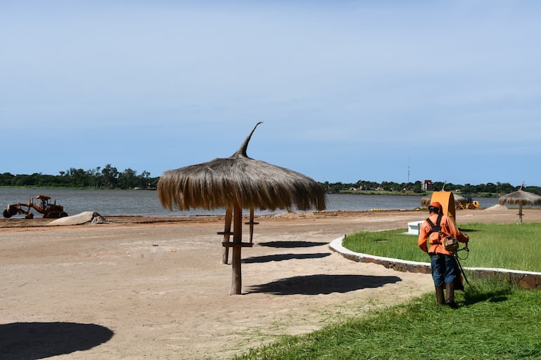 Trabajadores realizan tareas de mantenimiento en la playa Tacurú Pucú.