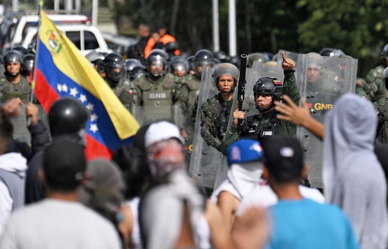 Guardia Nacional Bolivariana chocaba con los manifestantes ayer en Caracas. (AFP)