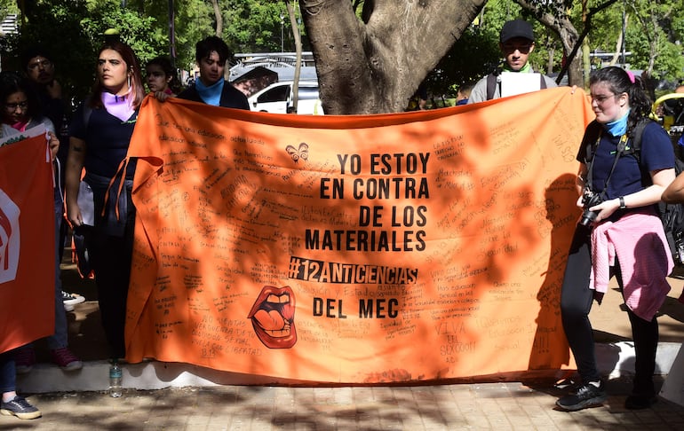 Jóvenes muestran una bandera de protesta contra el material "12 Ciencias" del MEC, en la plaza Juan E. O´Leary.