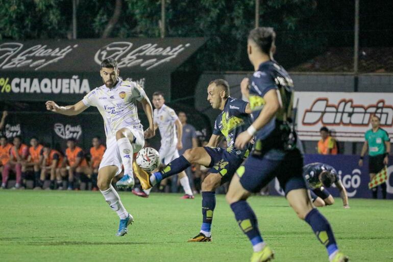 Luis de la Cruz trata de despejar el balón ante la marca de Rubén Darío Ríos