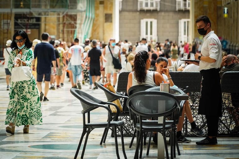 Un camarero atiende a los clientes en la terraza de un restaurante en Nápoles, Italia.