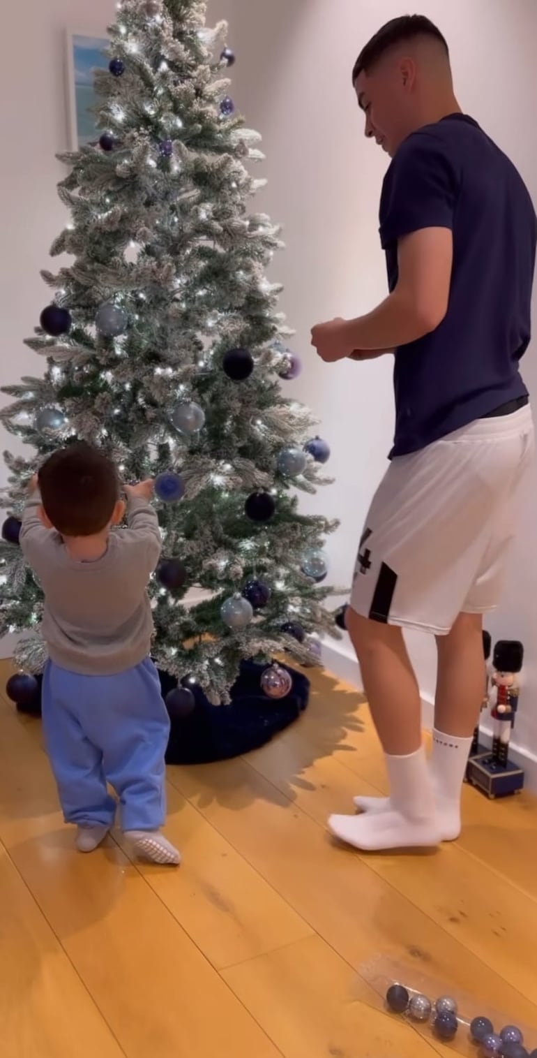 Francesco dando los toquecitos finales al arbolito navideño ante la atenta mirada de papá Miguel Almirón. (Instagram/Alexia Notto)