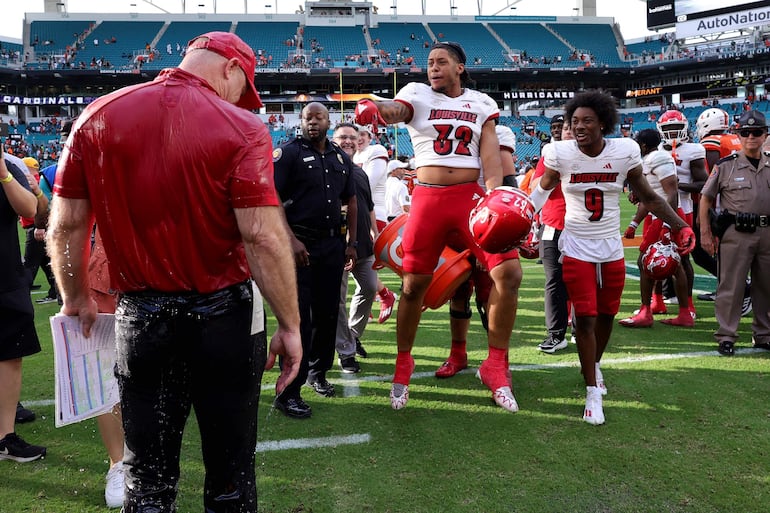 El entrenador en jefe Jeff Brohm y Ryheem Craig # 32 de los Louisville Cardinals celebran después de derrotar a los Miami Hurricanes en el Hard Rock Stadium el 18 de noviembre de 2023 en Miami Gardens, Florida.