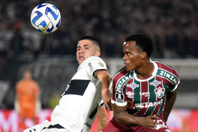 El defensor del Olimpia Mateo Gamarra (L) y el mediocampista colombiano del Fluminense Jhon Arias luchan por el balón durante el partido de vuelta de los cuartos de final de la Copa Libertadores entre el Olimpia de Paraguay y el Fluminense de Brasil en el estadio Defensores del Chaco en Asunción, el 31 de agosto de 2023.