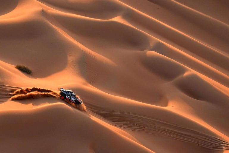 TOPSHOT - Team Audi Sport's Spanish driver Carlos Sainz and Spanish co-driver Lucas Cruz steer their car in the dunes during the second part of the 48h chrono stage between Shubaytah and Shubaytah on January 12, 2024, as part of the Dakar rally 2024. (Photo by PATRICK HERTZOG / AFP)